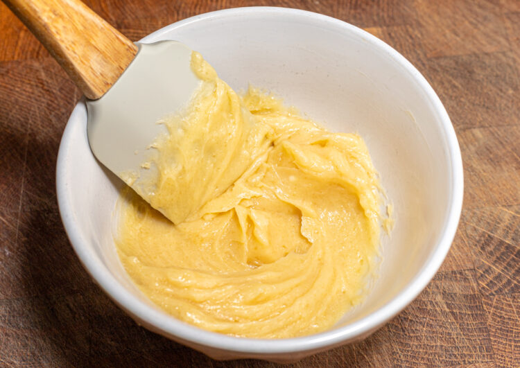 Creamy honey butter in a bowl with a spatula.