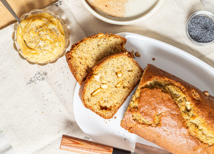 White chocolate poppy seed loaf cake sliced with honey butter on the side.