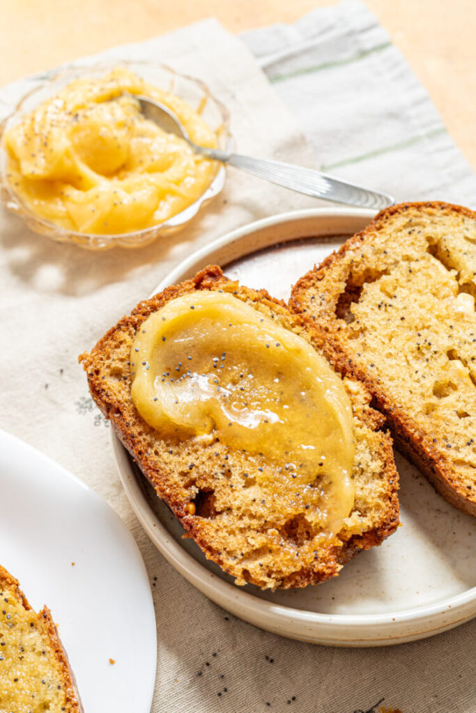 Slices of white chocolate poppy seed loaf cake with honey butter spread on top.
