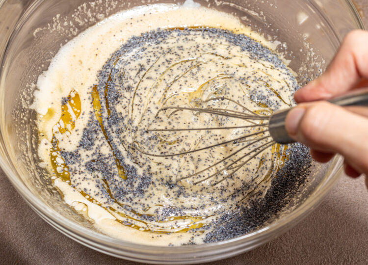 Whisking batter with poppy seeds.