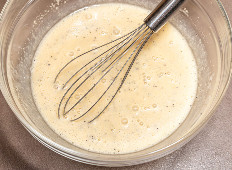 Bowl with foamy batter and a whisk.