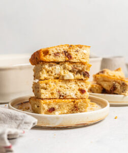 Feta and sun-dried tomato pastry slices stacked on a plate.