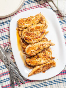 Pan-seared chicken fillets on a plate.