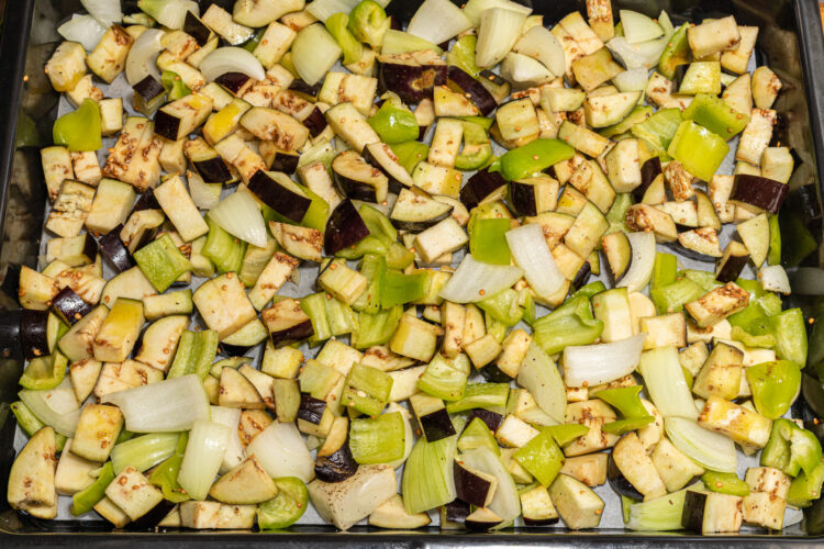 Chopped veggies seasoned on a baking tray.