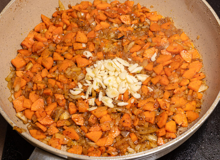 Added chopped garlic to a skillet with cooked onion and carrots.