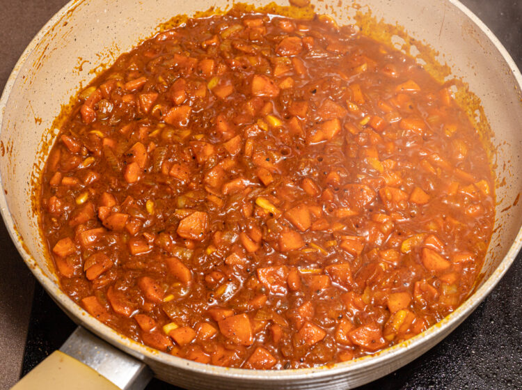 Cooking curry base sauce in a skillet.
